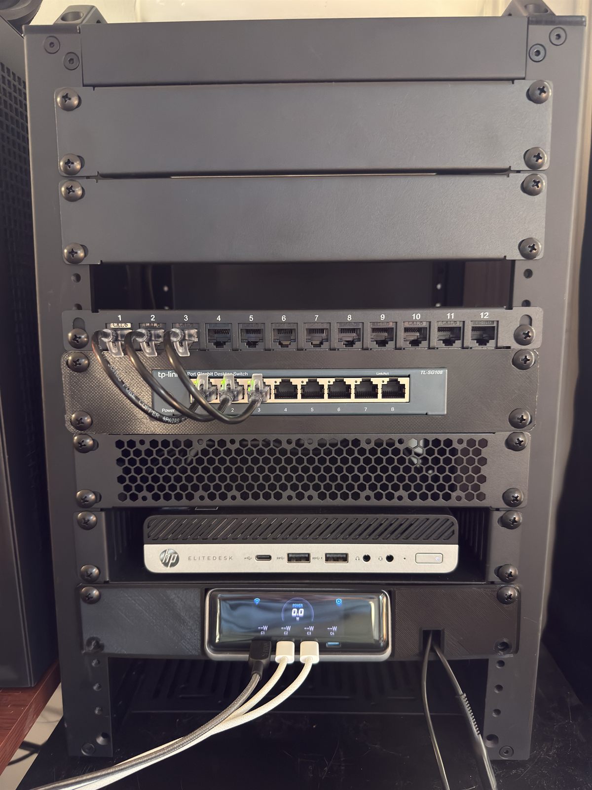 A 10-inch mini rack holding a patch panel, gigabit switch, and the HP EliteDesk Mini that runs the homelab